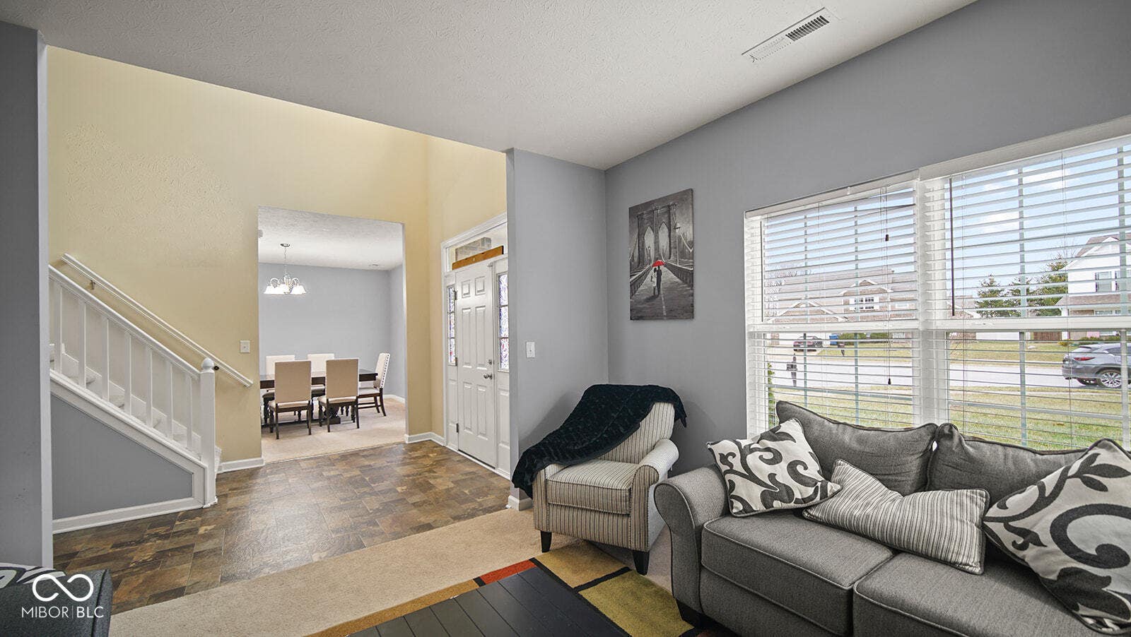 living room with baseboards, visible vents, a notable chandelier, and stairway