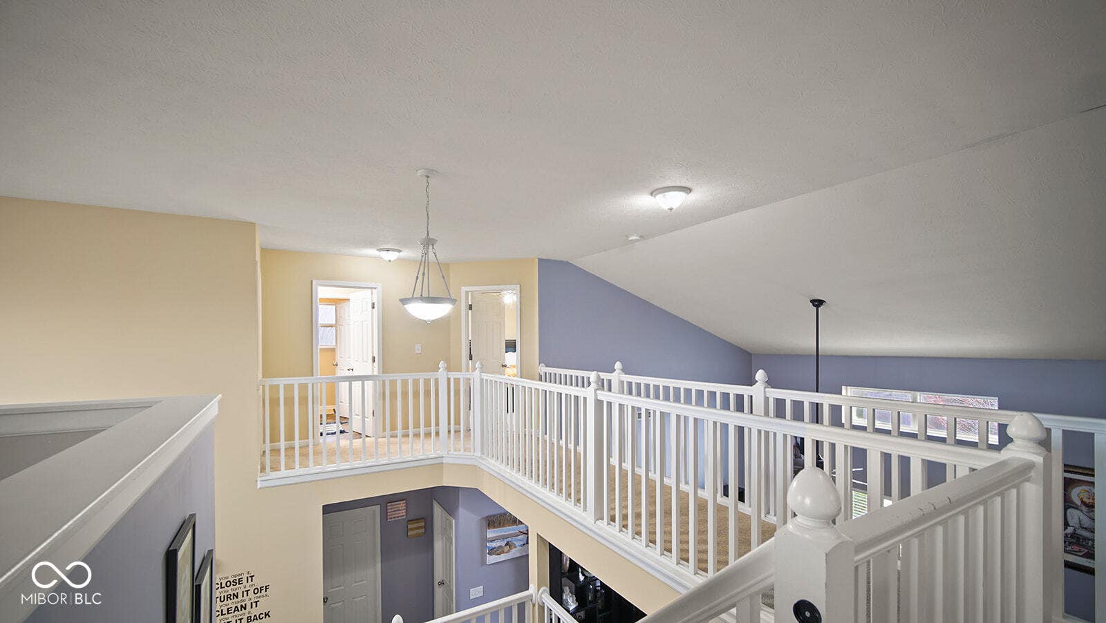 hall with an upstairs landing and vaulted ceiling