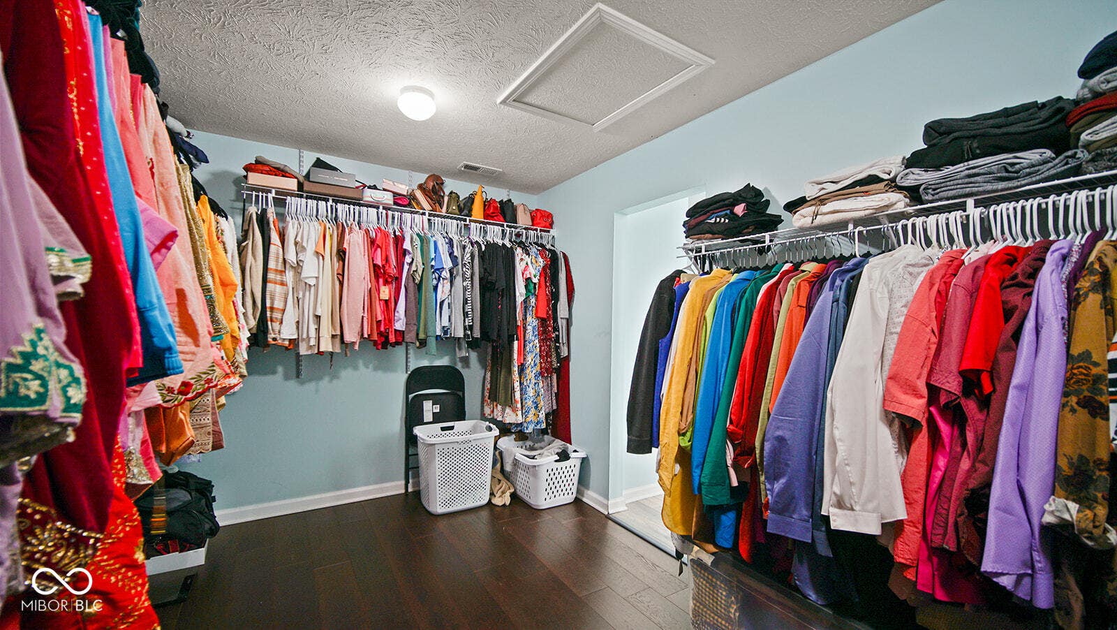 spacious closet featuring attic access, visible vents, and wood finished floors