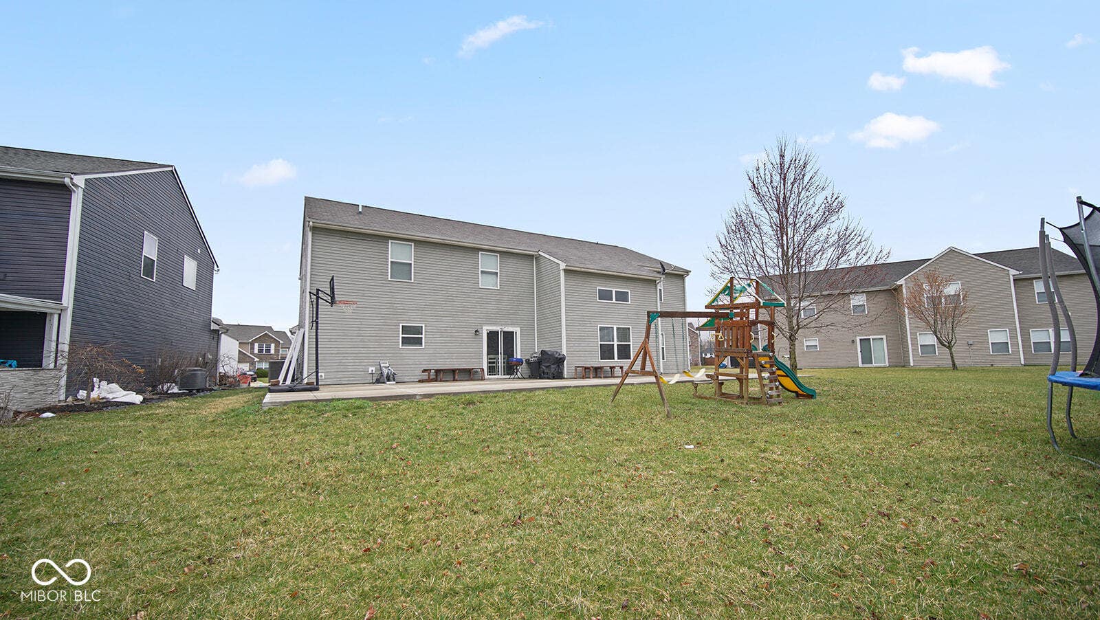 rear view of property featuring a trampoline, a playground, central AC, a yard, and a patio area