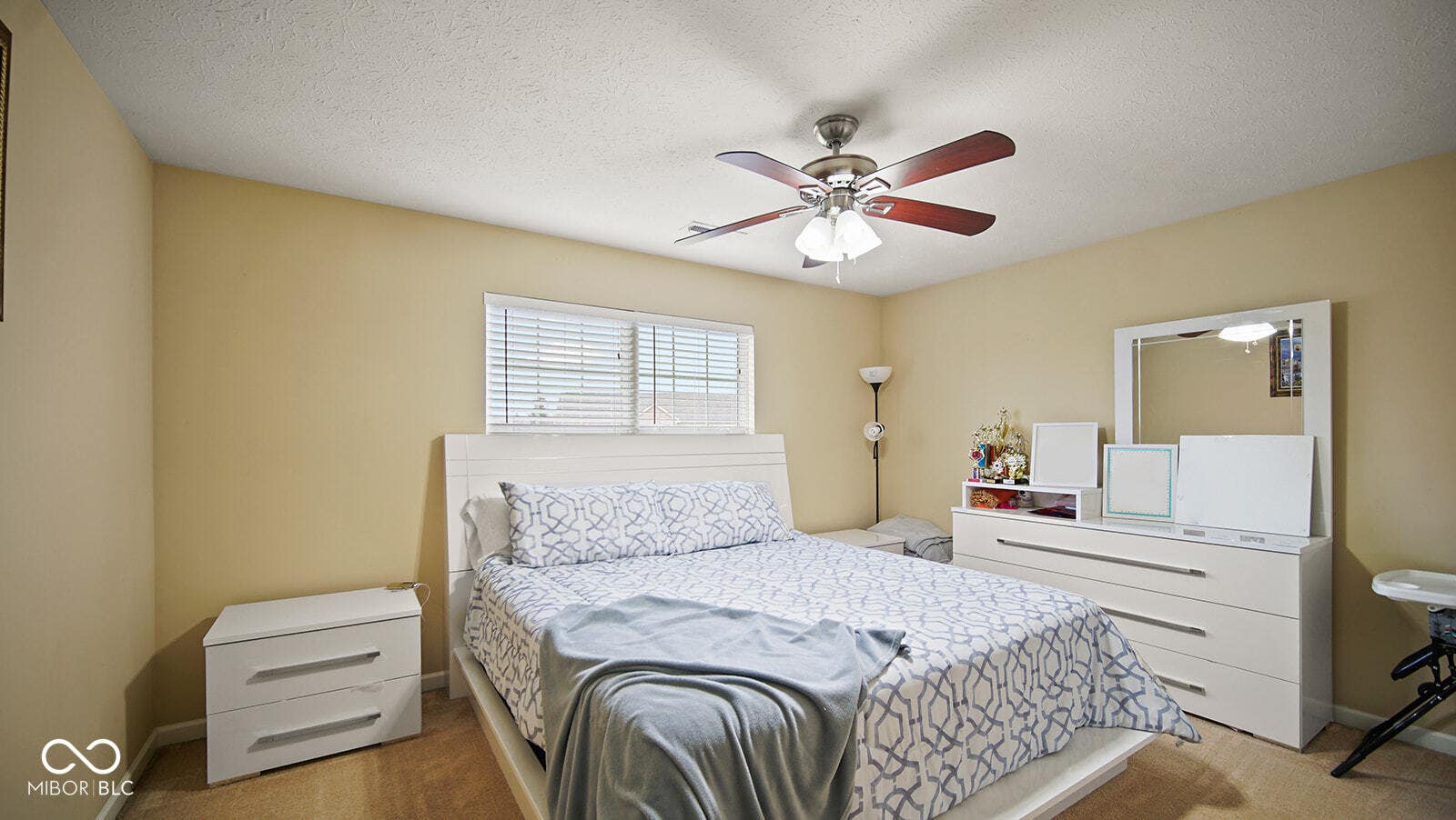carpeted bedroom featuring baseboards, ceiling fan, and a textured ceiling