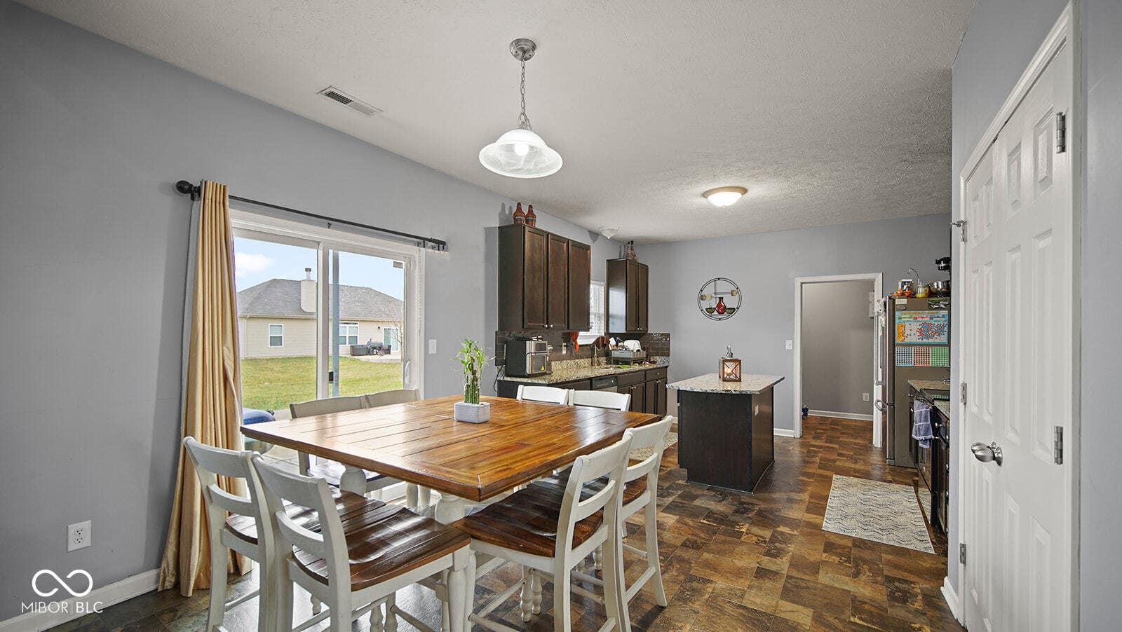 dining area featuring baseboards, visible vents, stone finish flooring, and a textured ceiling