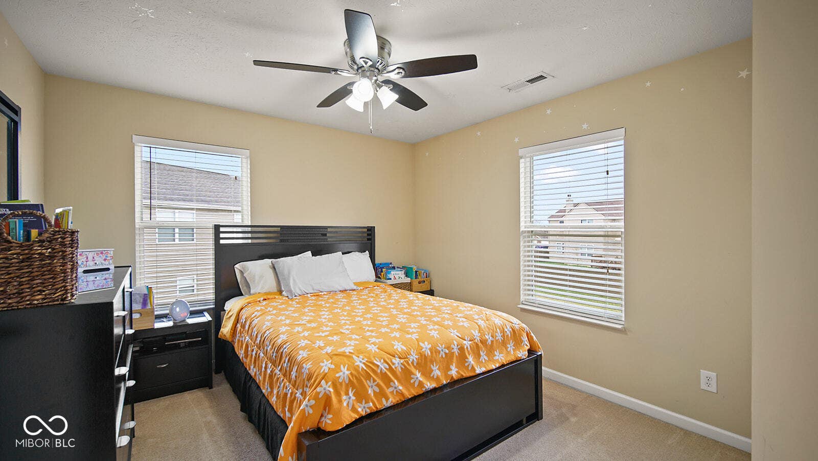 bedroom with baseboards, visible vents, multiple windows, and light colored carpet