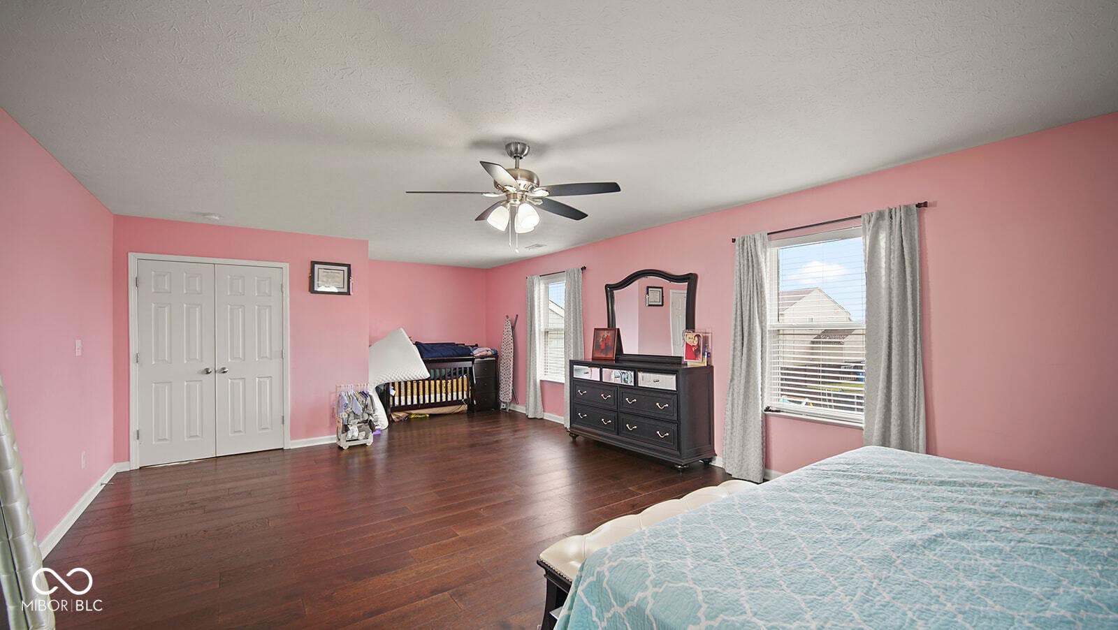 bedroom featuring baseboards, a textured ceiling, ceiling fan, and wood finished floors