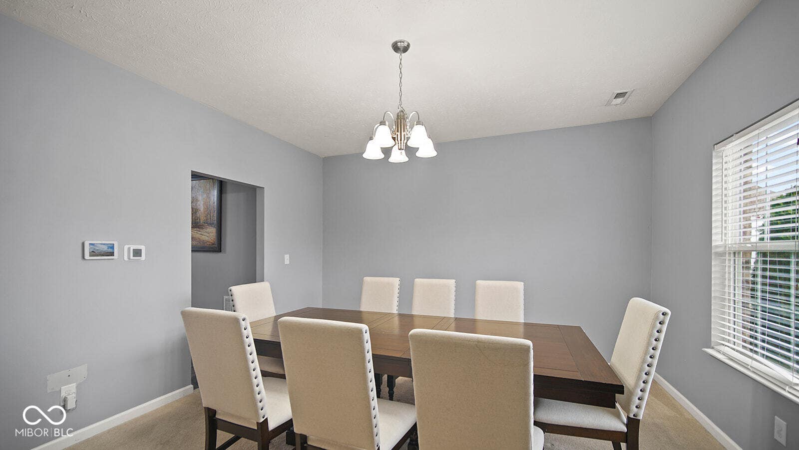 dining area with baseboards, visible vents, carpet floors, and an inviting chandelier