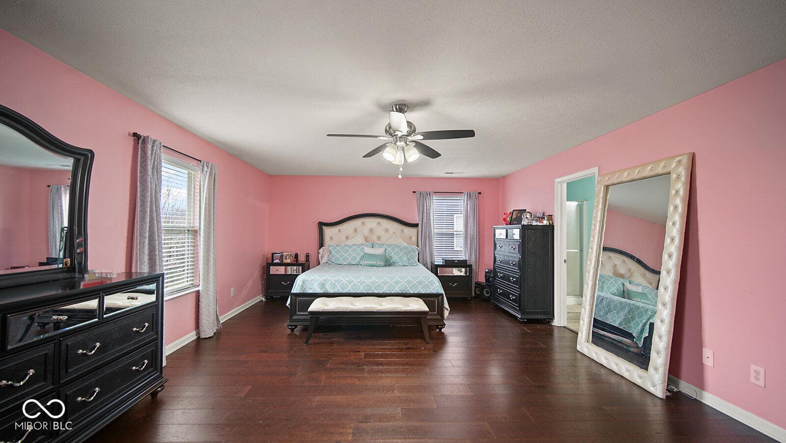 bedroom featuring baseboards, wood finished floors, and multiple windows
