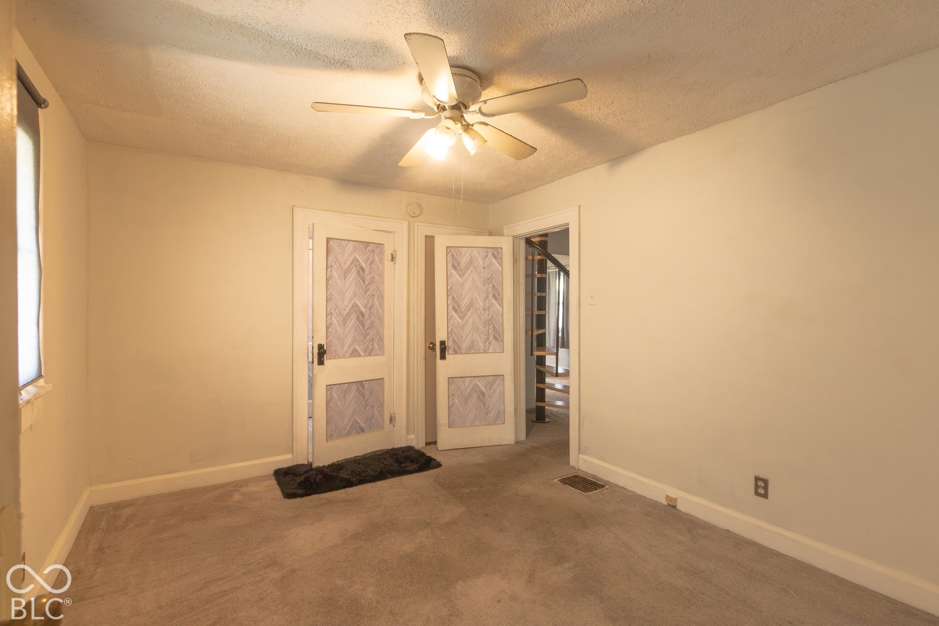 Wall-to-wall carpeting, ceiling fan, and painted walls