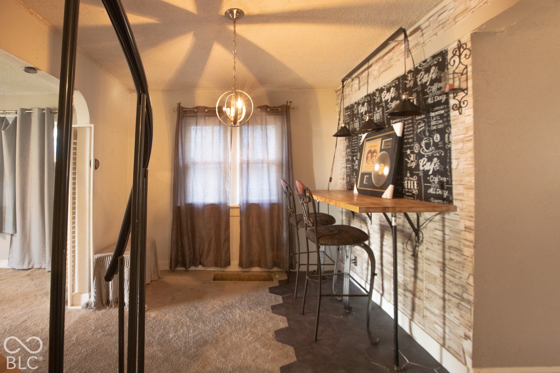 Wall-mounted bar with wood-finish countertop, pendant lighting, and textured wall treatment