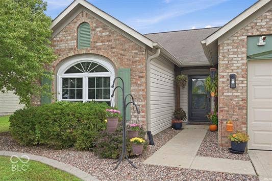 Brick facade with a prominent arched window and decorative green shutters