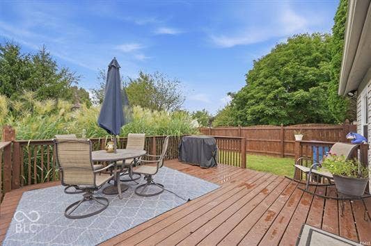 Spacious wood-finish deck with a privacy fence and mature perimeter landscaping