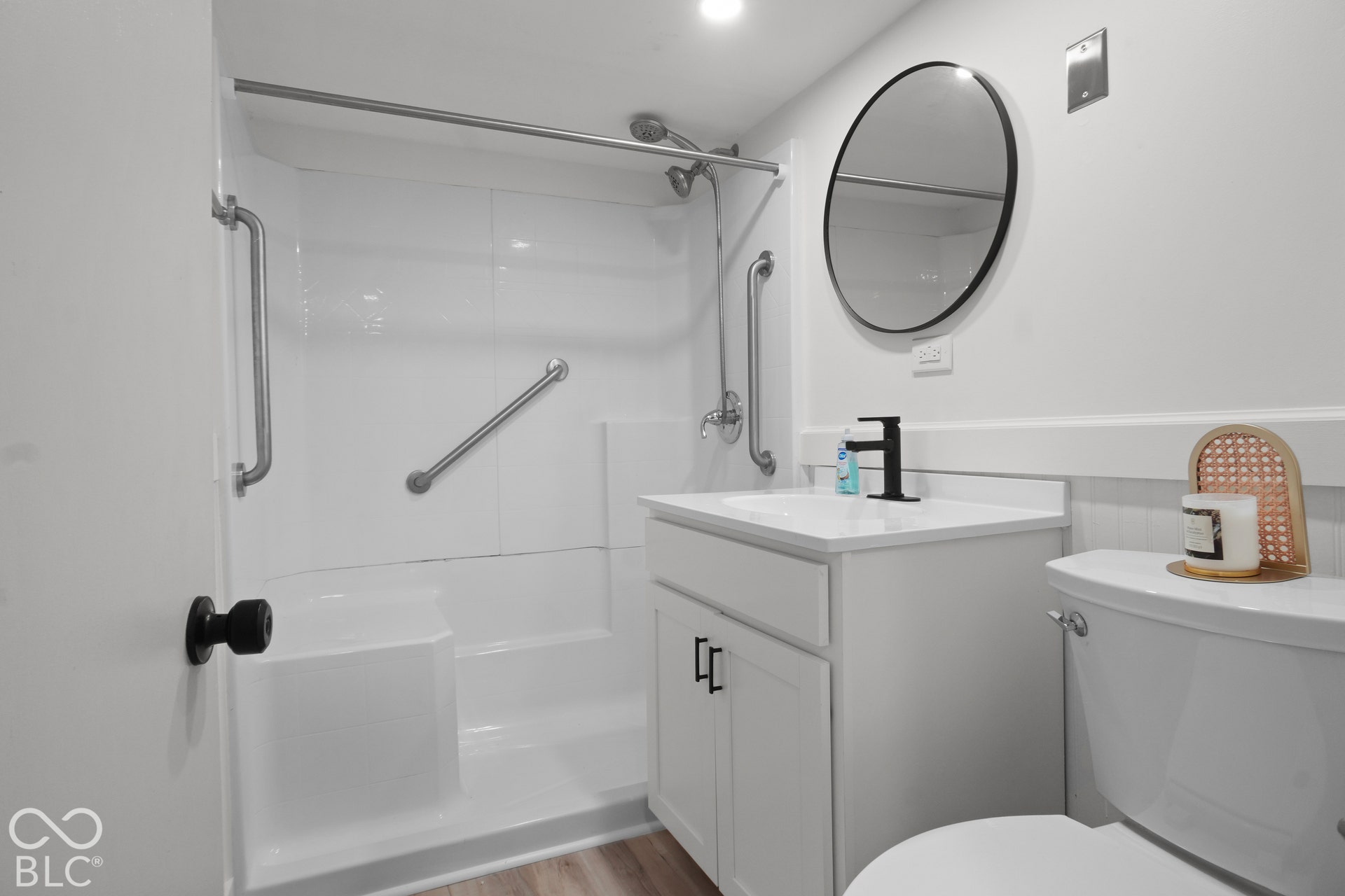 White shower enclosure with integrated seating and grab bars