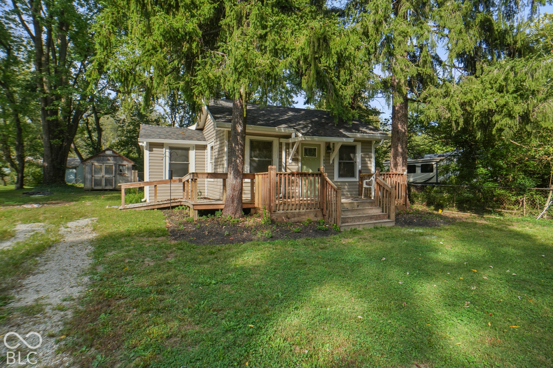 Siding exterior with a covered entry, wood-finish porch, and an accessibility ramp