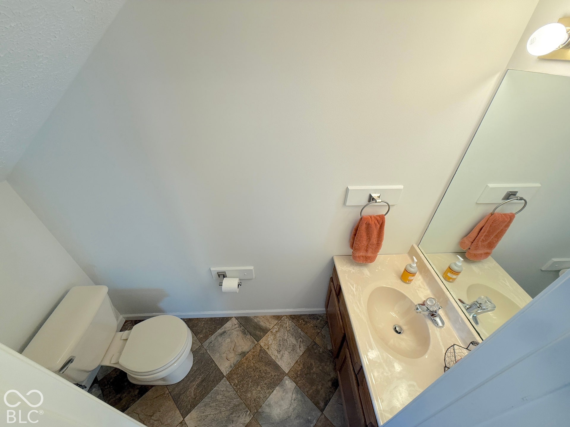 Vanity with integrated sink, full-width mirror, and overhead light fixture