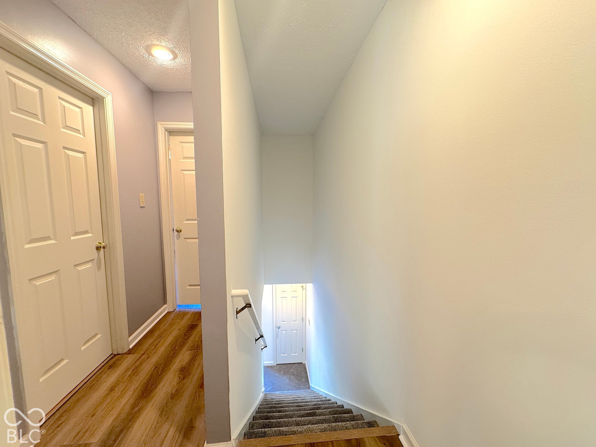 Hallway with wood-finish flooring and flush mount lighting