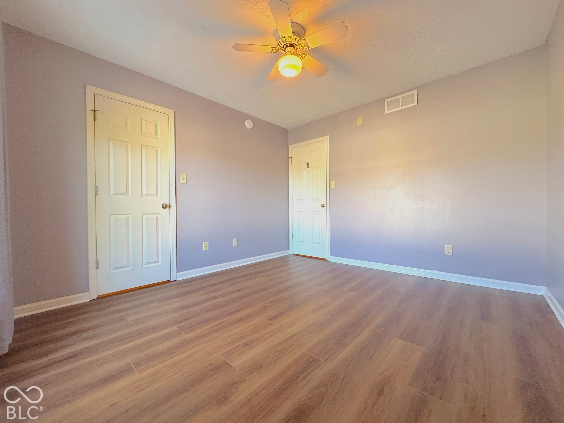 Wood-finish flooring throughout, complemented by a ceiling fan with integrated lighting
