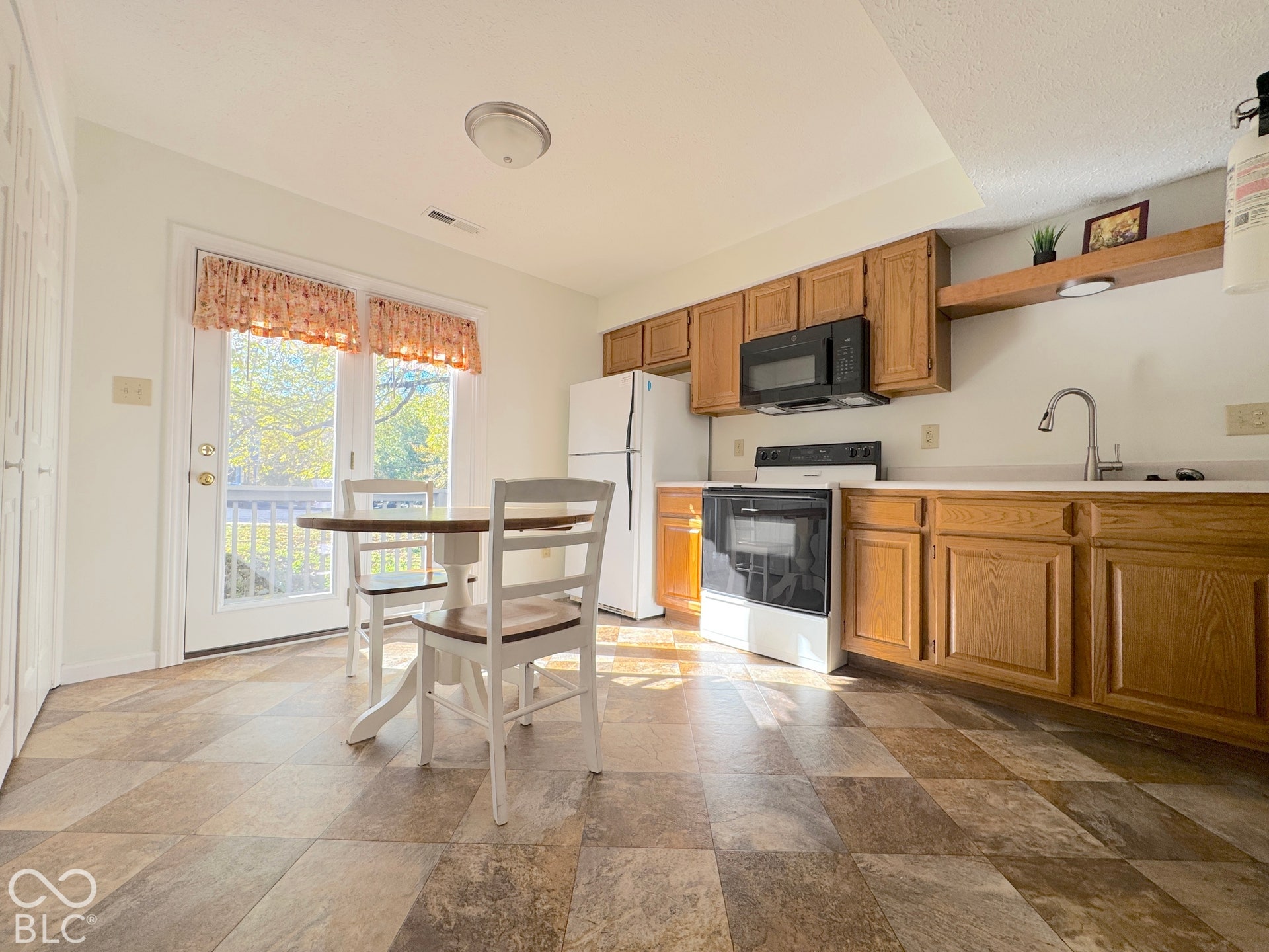 Kitchen featuring wood-finish cabinetry, white countertops, a stainless-steel sink with a gooseneck faucet, and integrated appliances