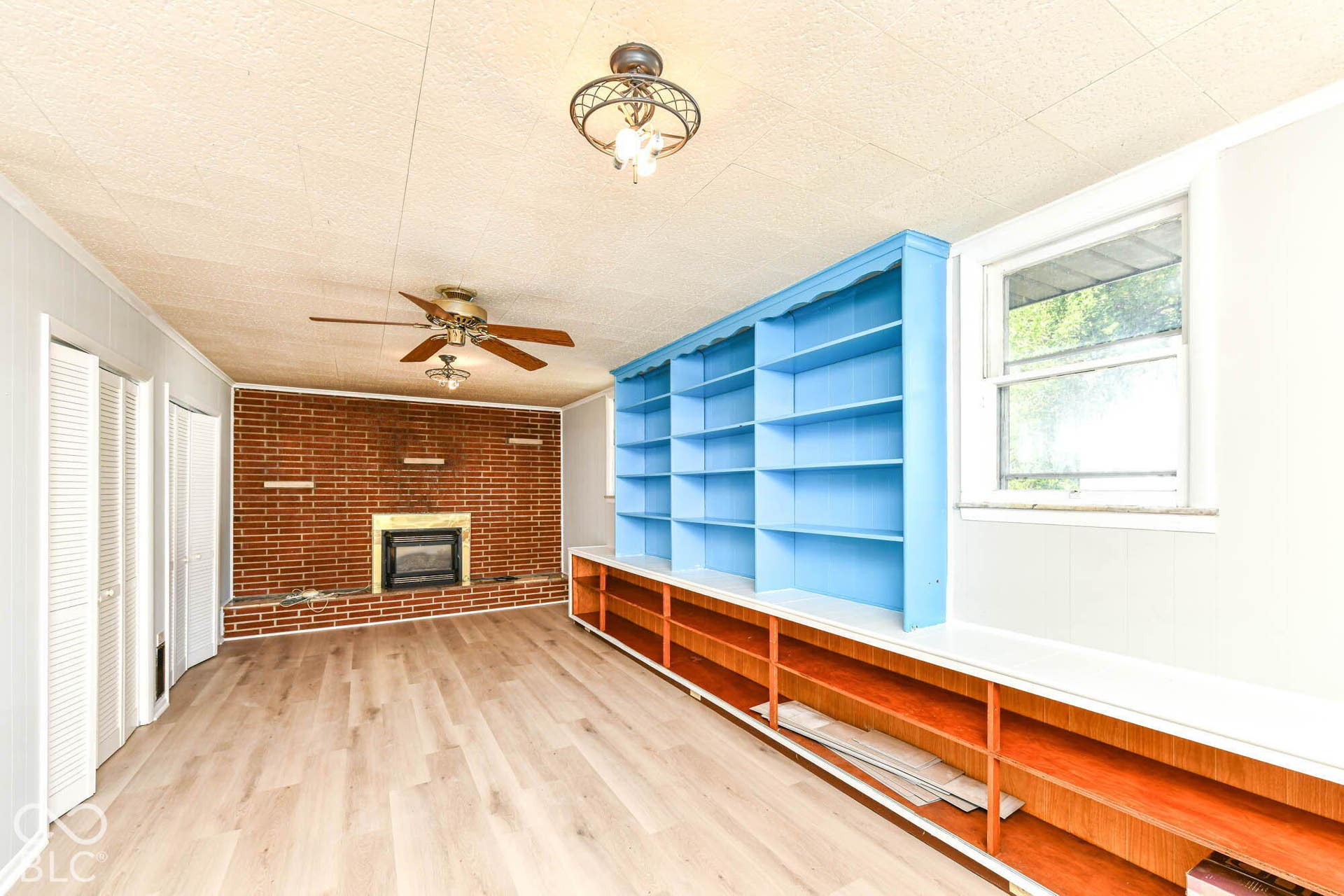 6401 Orinoco Avenue, Indianapolis, IN 46227 Wood-finish flooring, brick fireplace, built-in shelving, ceiling fan, and window