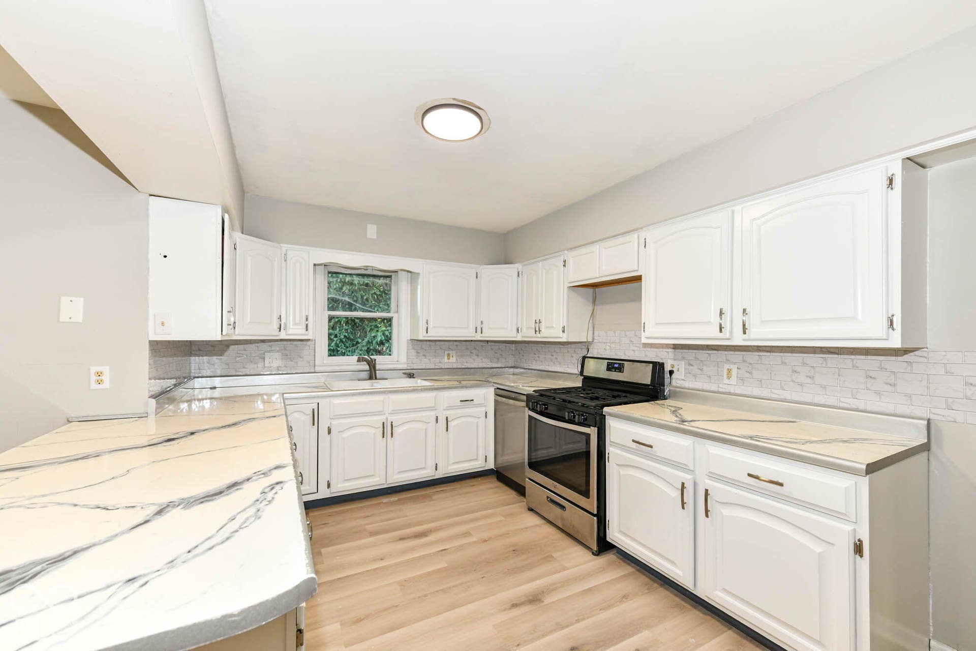 6401 Orinoco Avenue, Indianapolis, IN 46227 White cabinetry, wood-finish flooring, stainless steel range, and stone-finish countertops