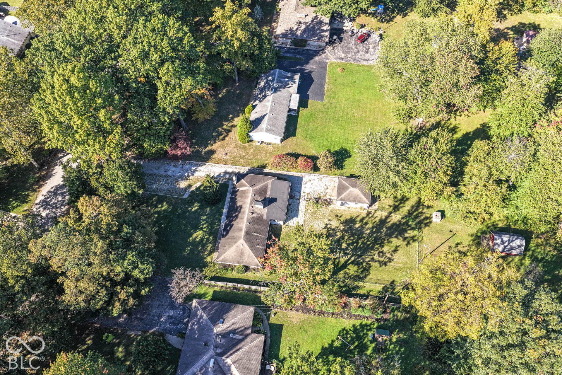 6401 Orinoco Avenue, Indianapolis, IN 46227 Aerial perspective showcasing multiple residential properties, expansive green spaces, and mature tree coverage