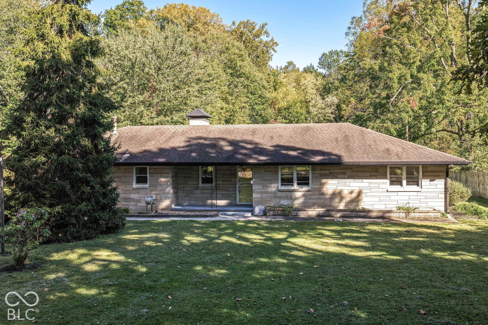 6401 Orinoco Avenue, Indianapolis, IN 46227 Stone exterior with a shingle roof and a concrete patio