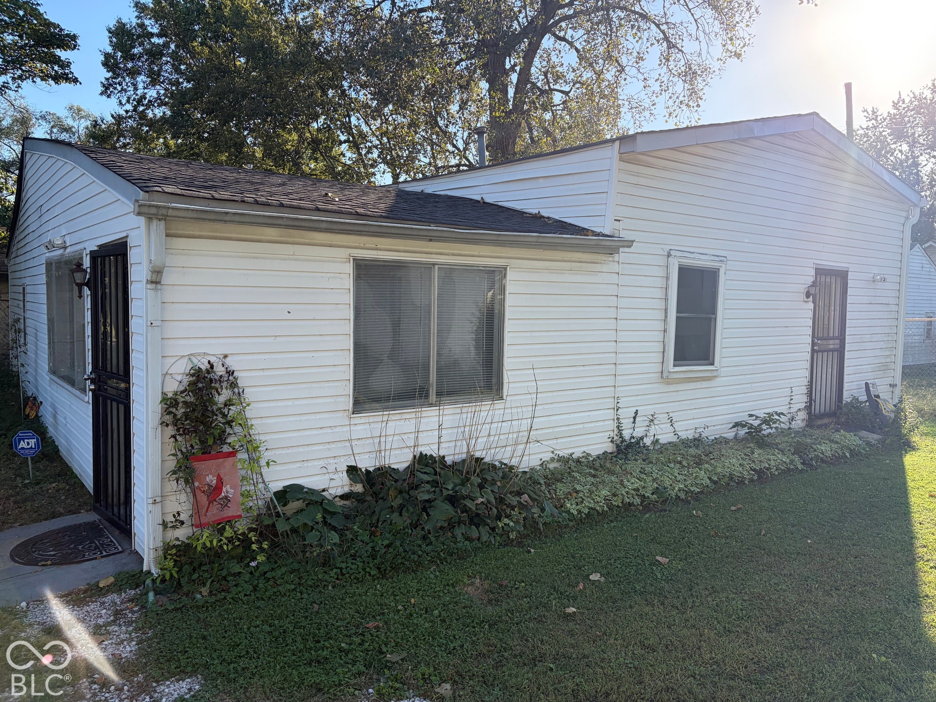 White siding exterior with a dark shingle roof and multiple windows