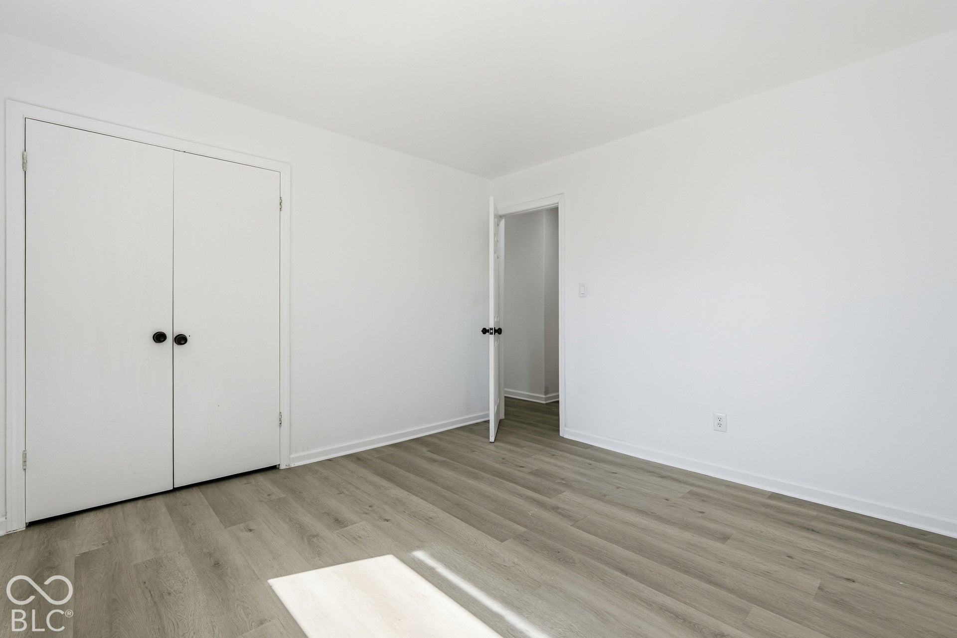 Bright interior with light wood-finish flooring, white walls, and a white ceiling