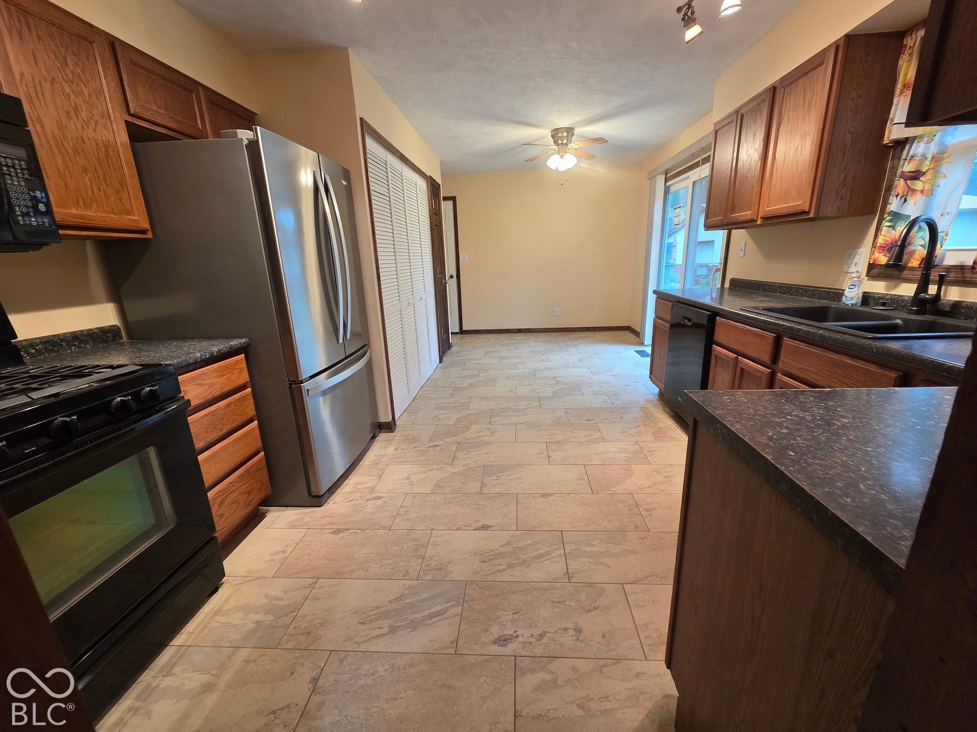 6614 Weil Drive, Brownsburg, IN 46112 Kitchen featuring full-size stainless steel refrigerator, black gas range/oven, and black dishwasher.