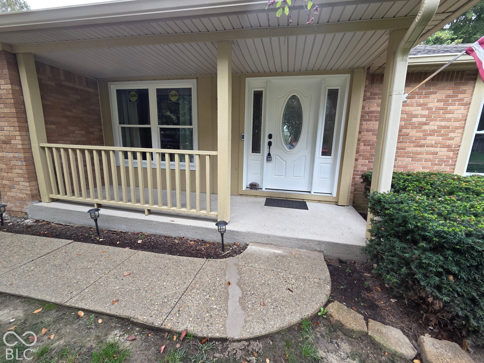 6614 Weil Drive, Brownsburg, IN 46112 Brick exterior with white trim, covered front porch, white entry door with oval glass insert, and sidelight windows