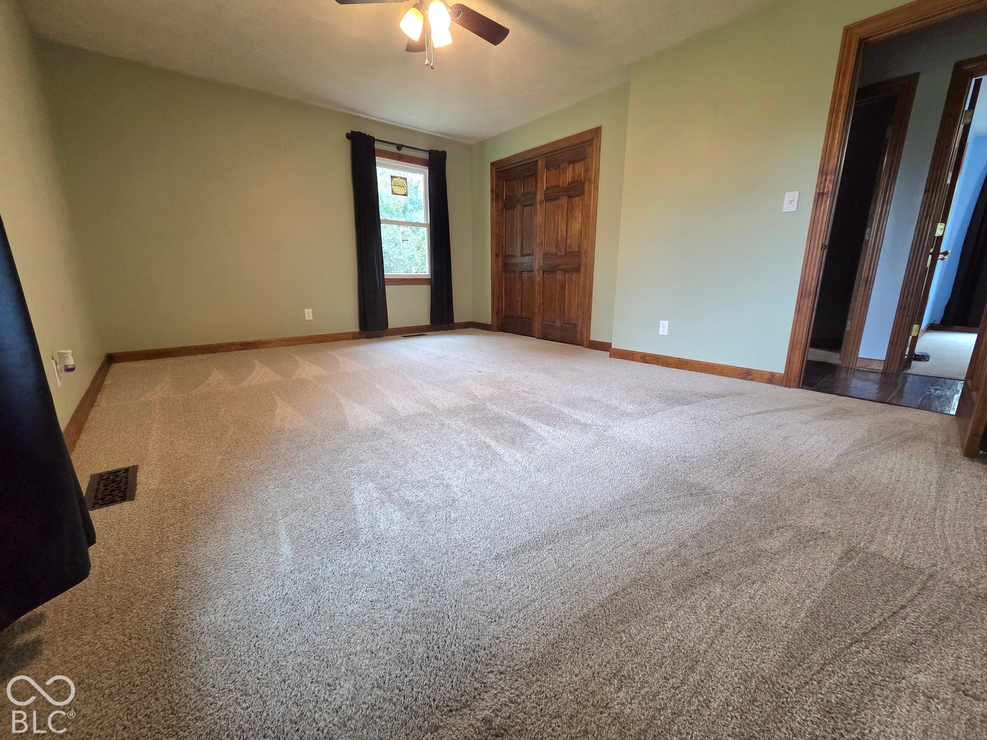 6614 Weil Drive, Brownsburg, IN 46112 Spacious room with light neutral carpeting, wood-finish trim, and a ceiling fan