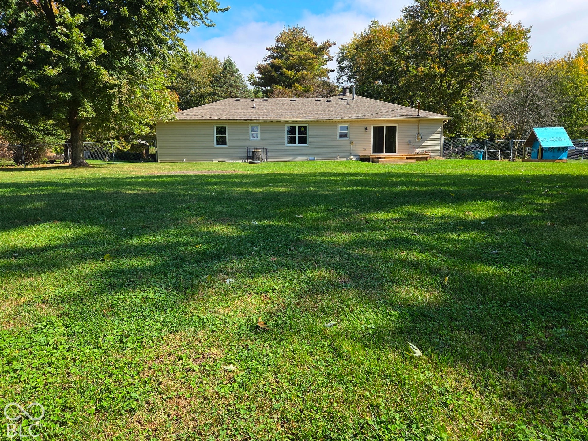 6614 Weil Drive, Brownsburg, IN 46112 Large fully fenced back yard with mature trees and a wooden deck.