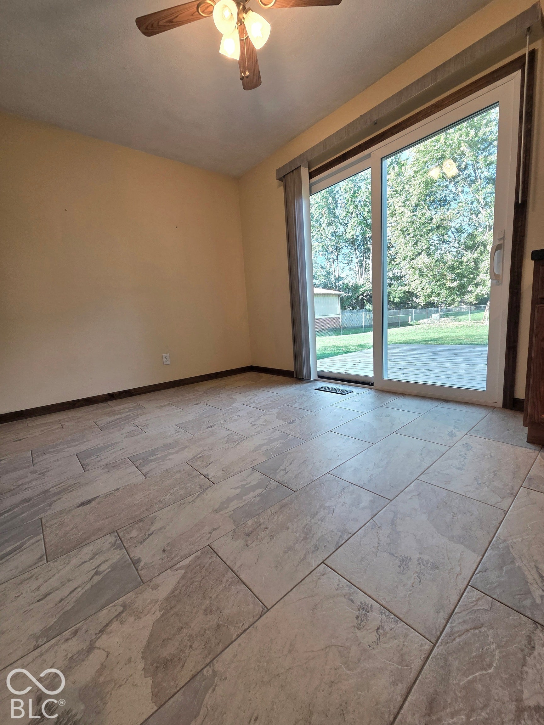 6614 Weil Drive, Brownsburg, IN 46112 Rectangular tile flooring, a ceiling fan with integrated lighting, and a sliding glass door providing direct outdoor access