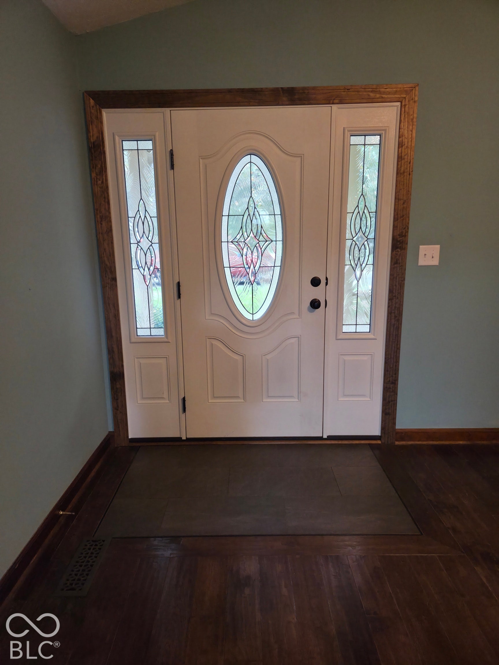 6614 Weil Drive, Brownsburg, IN 46112 Entry door with decorative glass inserts, flanked by matching sidelights, set within wood-finish trim