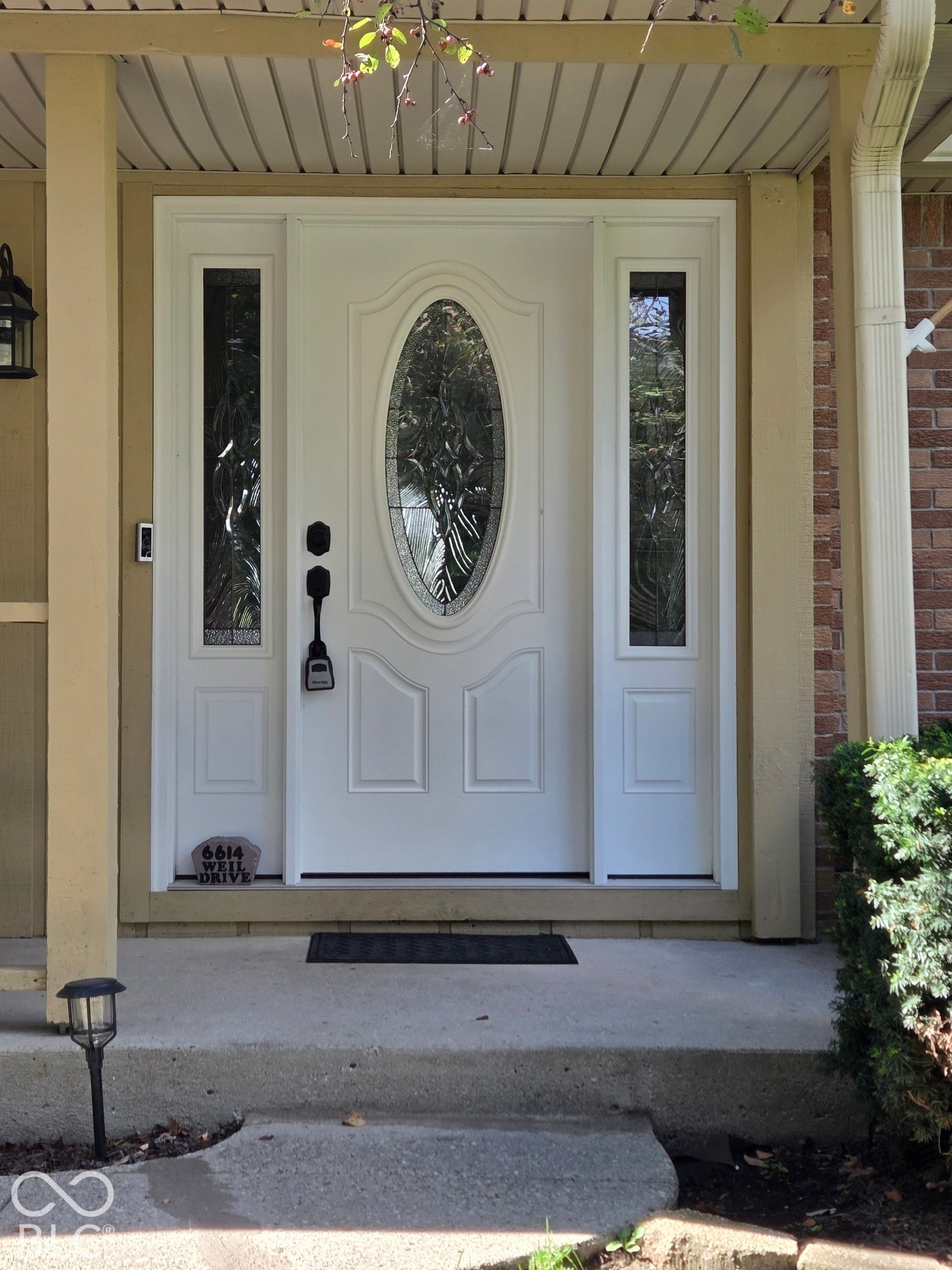 6614 Weil Drive, Brownsburg, IN 46112 White entry door with decorative oval glass insert, flanked by two full-length sidelights, under a soffit-paneled porch ceiling