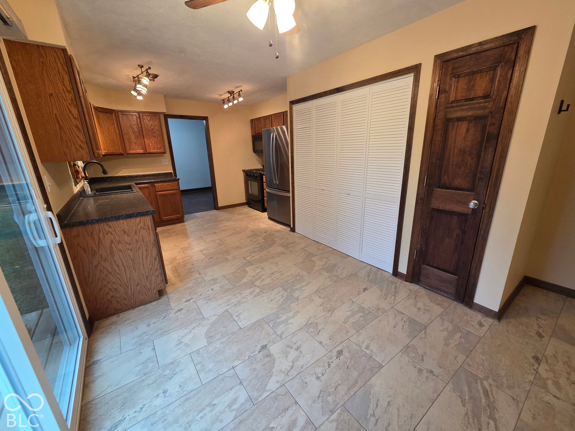 6614 Weil Drive, Brownsburg, IN 46112 Kitchen featuring wood cabinetry, dark countertops, and stainless steel refrigerator.