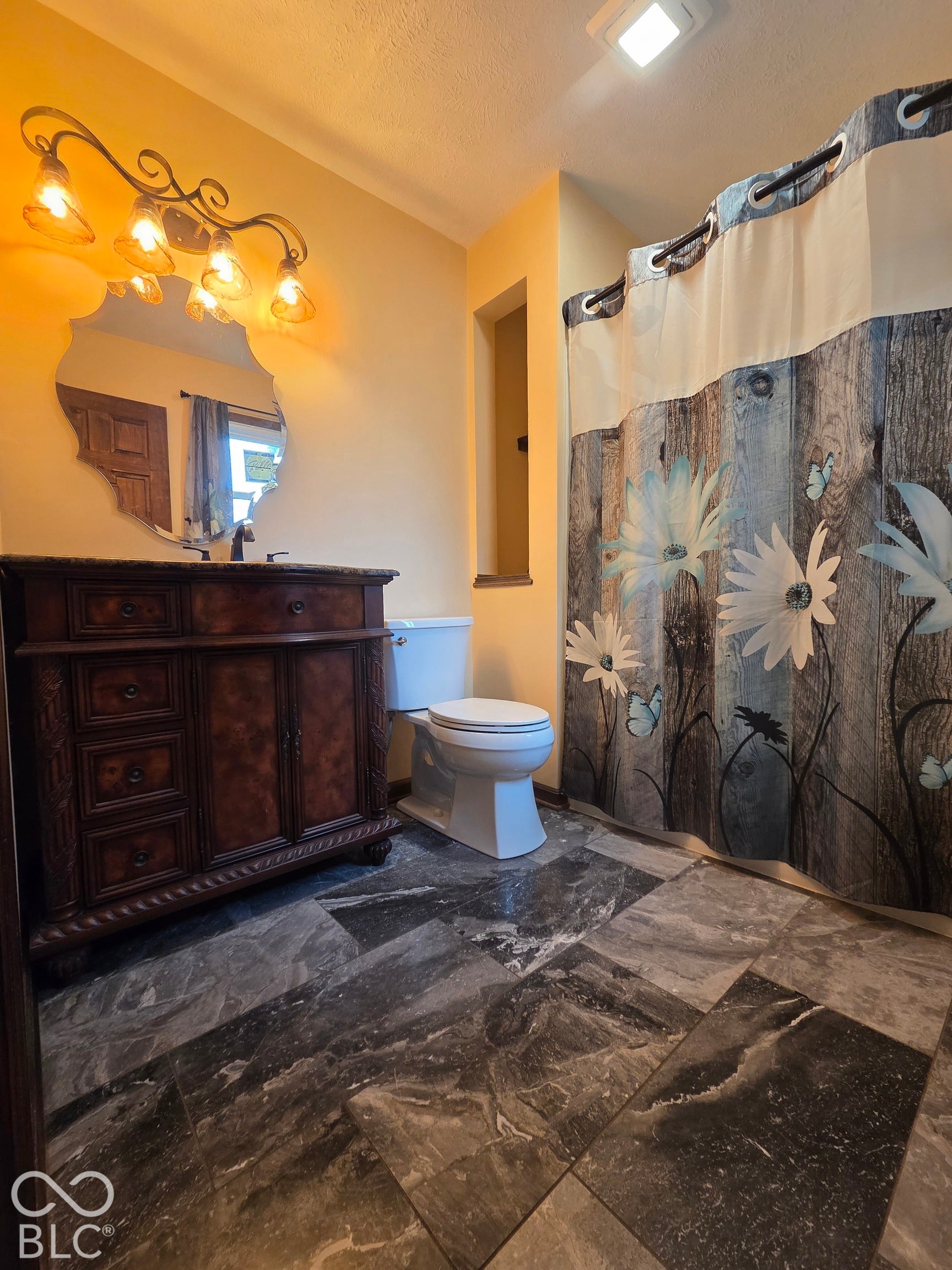 6614 Weil Drive, Brownsburg, IN 46112 Decorative vanity with a stone countertop, a shaped mirror, and an ornate four-light fixture