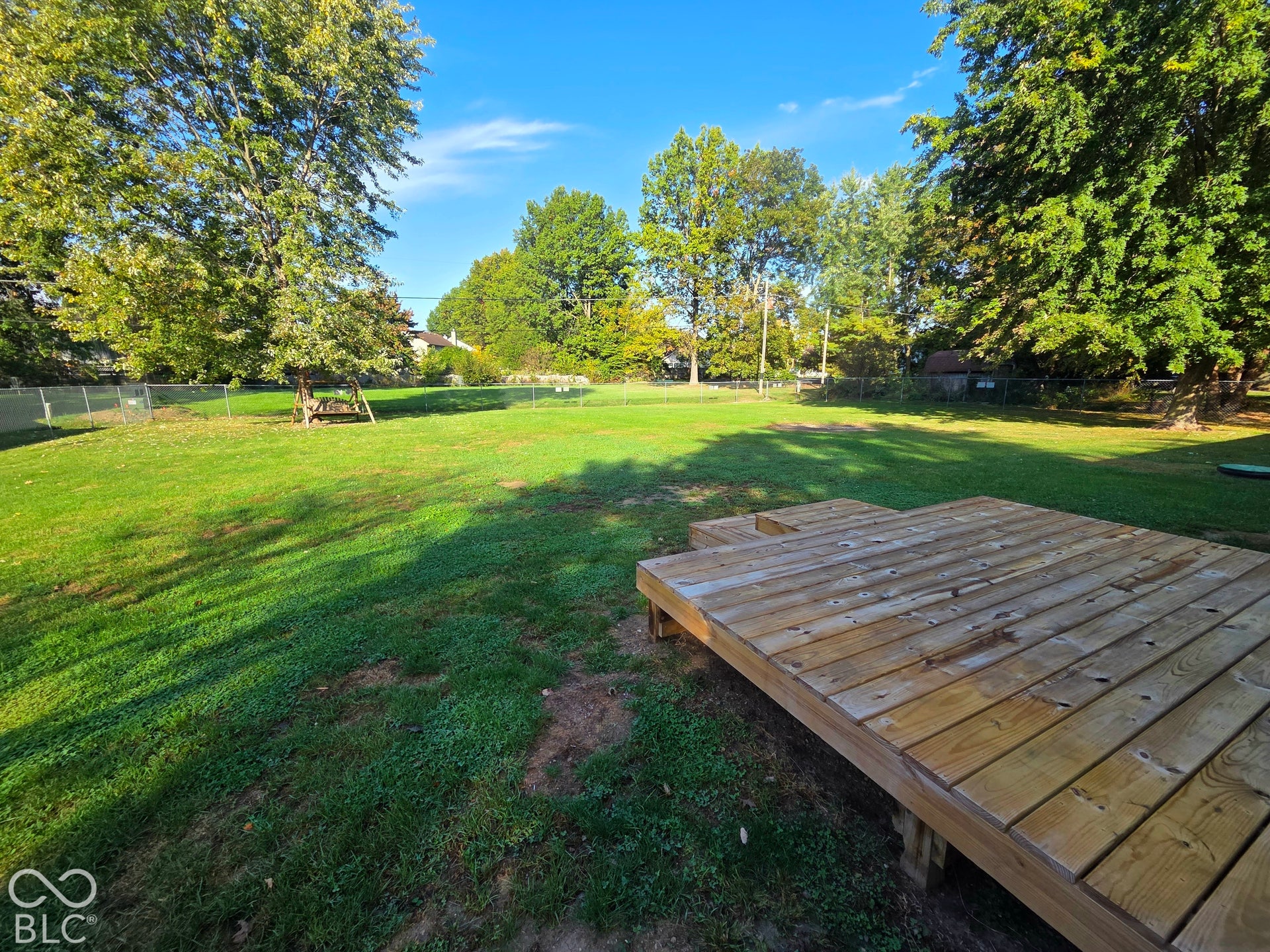 6614 Weil Drive, Brownsburg, IN 46112 Wooden deck, mature trees, and a chain-link fence.