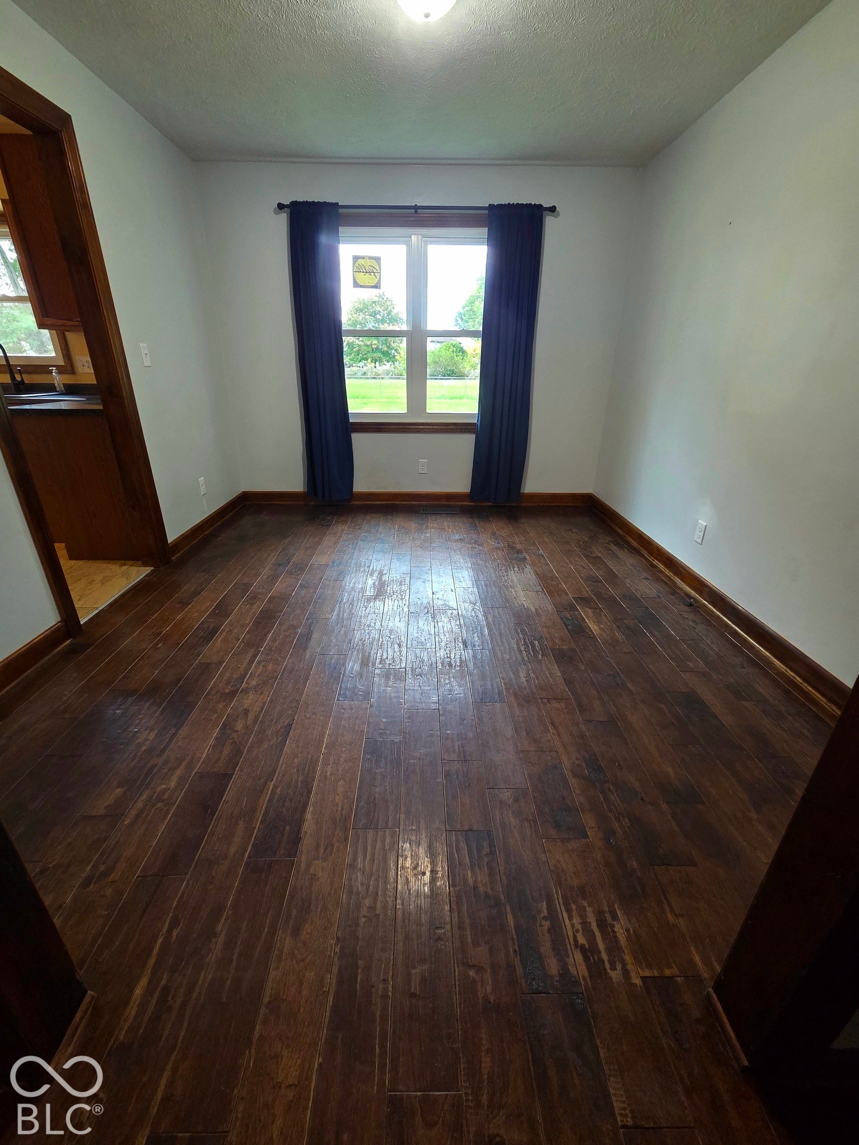 6614 Weil Drive, Brownsburg, IN 46112 Dark wood-finish flooring, white walls, and a window with trim