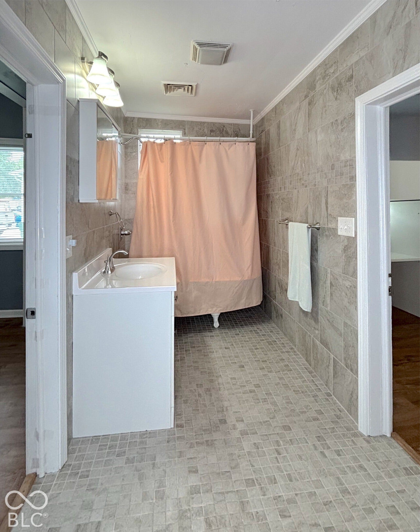 311 B Street S, Thorntown, IN 46071 Bathroom featuring full-height tiled walls, tiled flooring, a single vanity with a basin sink, and a clawfoot tub