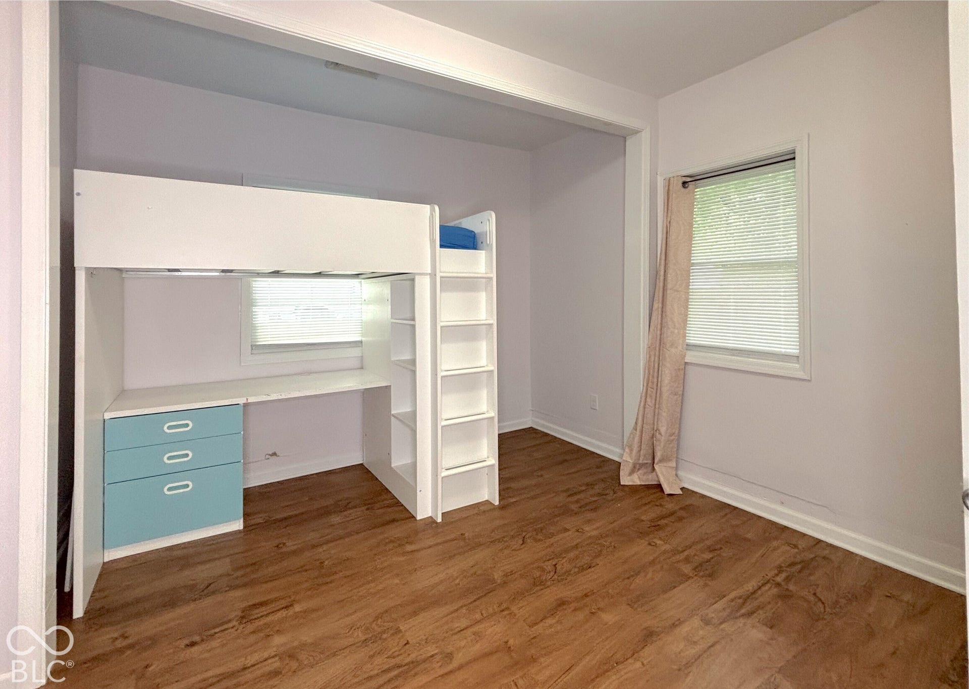 311 B Street S, Thorntown, IN 46071 Wood-finish flooring with white baseboards and a built-in loft bed frame with integrated desk and shelving
