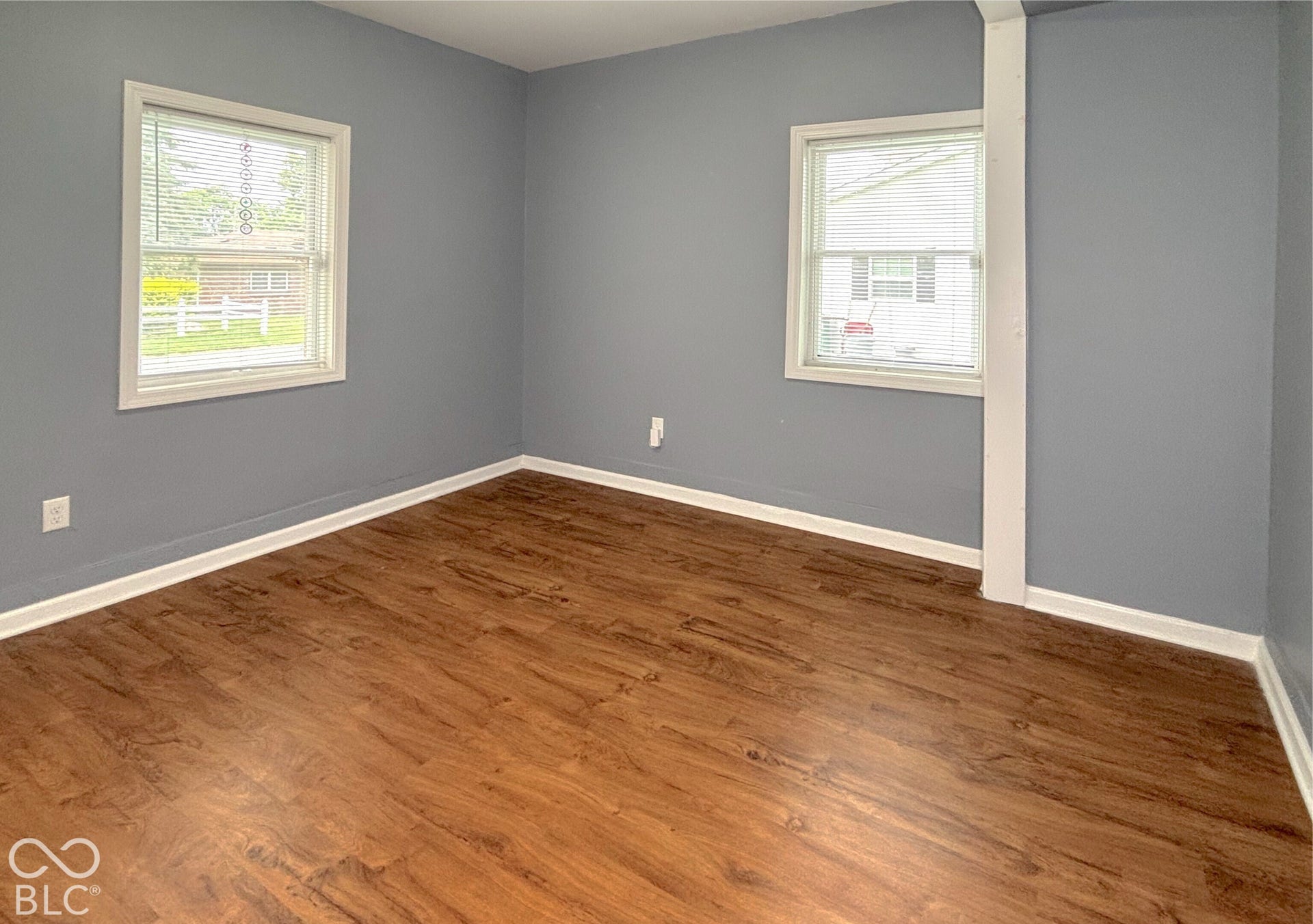 311 B Street S, Thorntown, IN 46071 Wood-finish flooring with white trim, two windows, and a built-in column