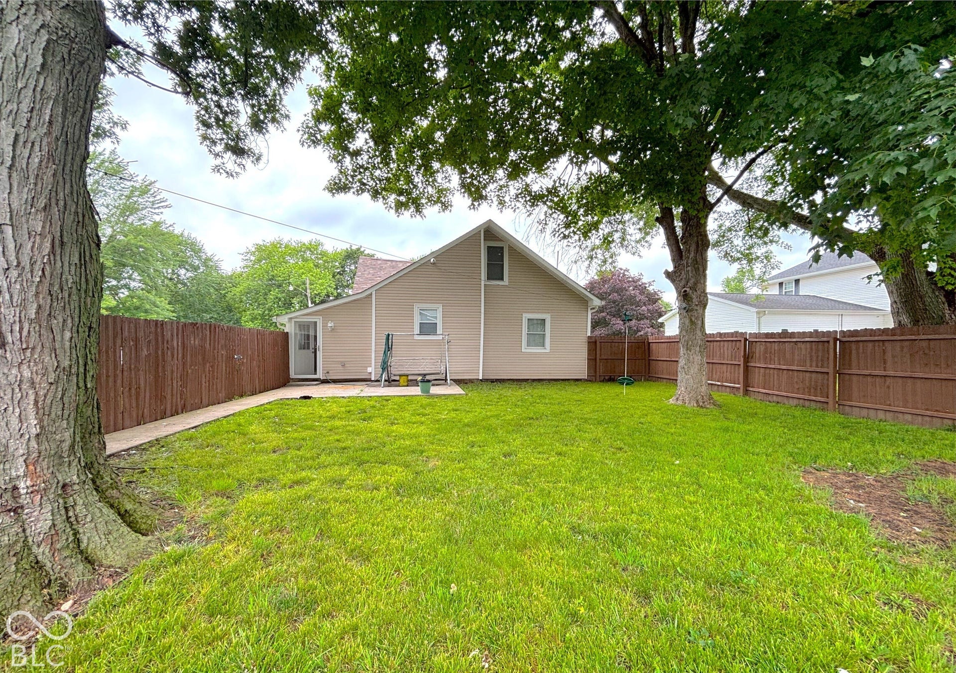 311 B Street S, Thorntown, IN 46071 Expansive backyard with a manicured lawn, established trees, and a full privacy fence