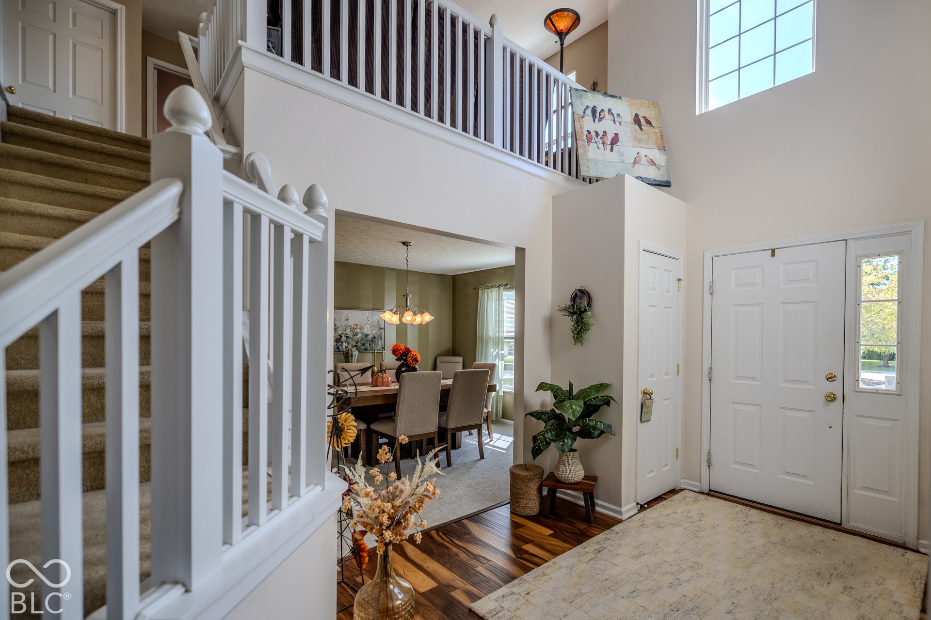 12046 Cowboys, Fishers, IN 46037 Welcoming foyer with soaring two-story ceilings, abundant natural light from transom windows, and hardwood flooring