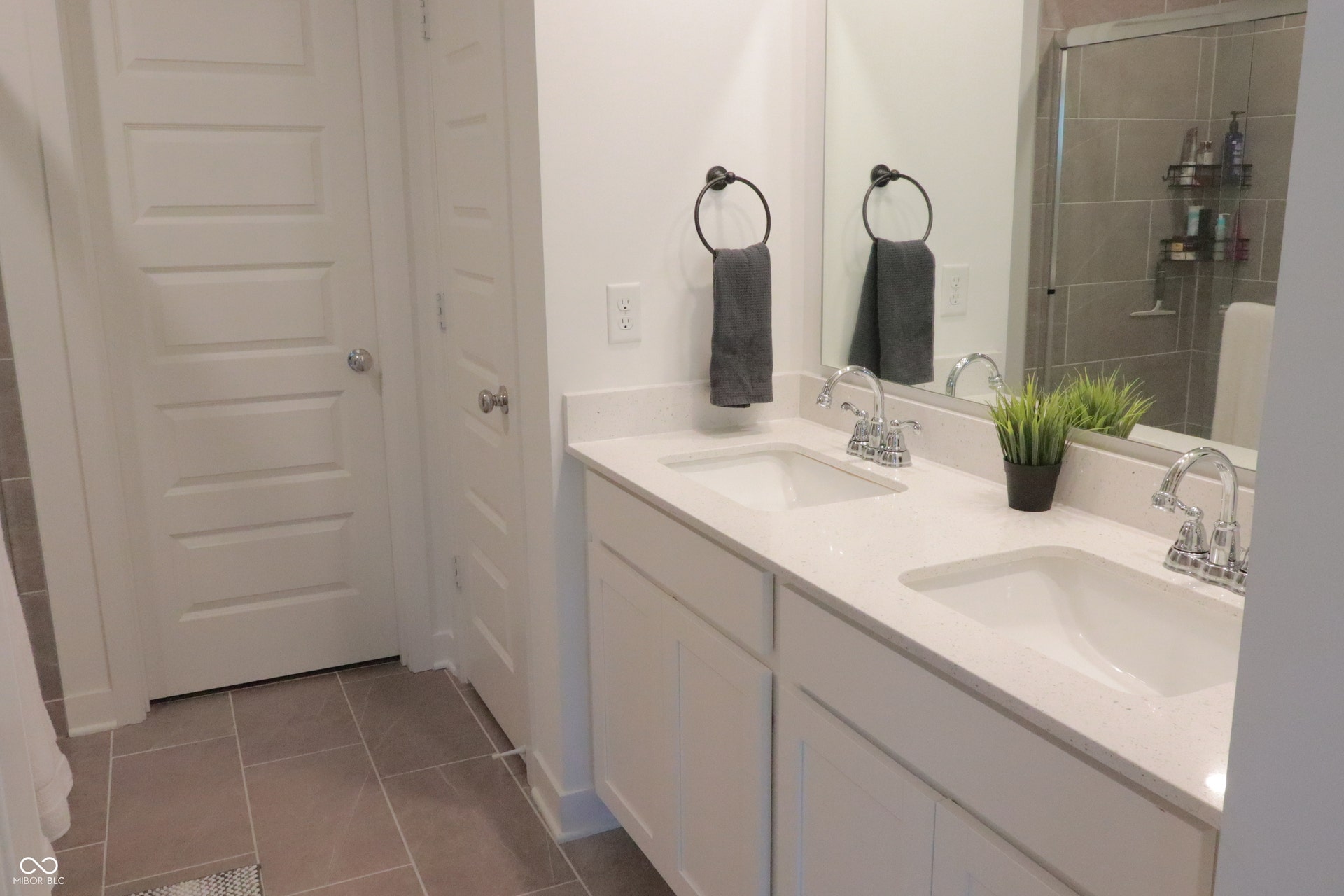Double vanity featuring undermount sinks, chrome fixtures, and a light-toned countertop