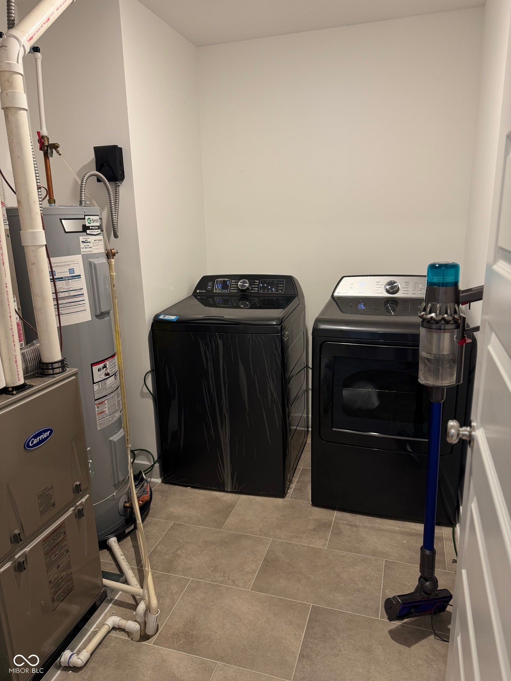 Dedicated utility space featuring a water heater, furnace, and tiled flooring