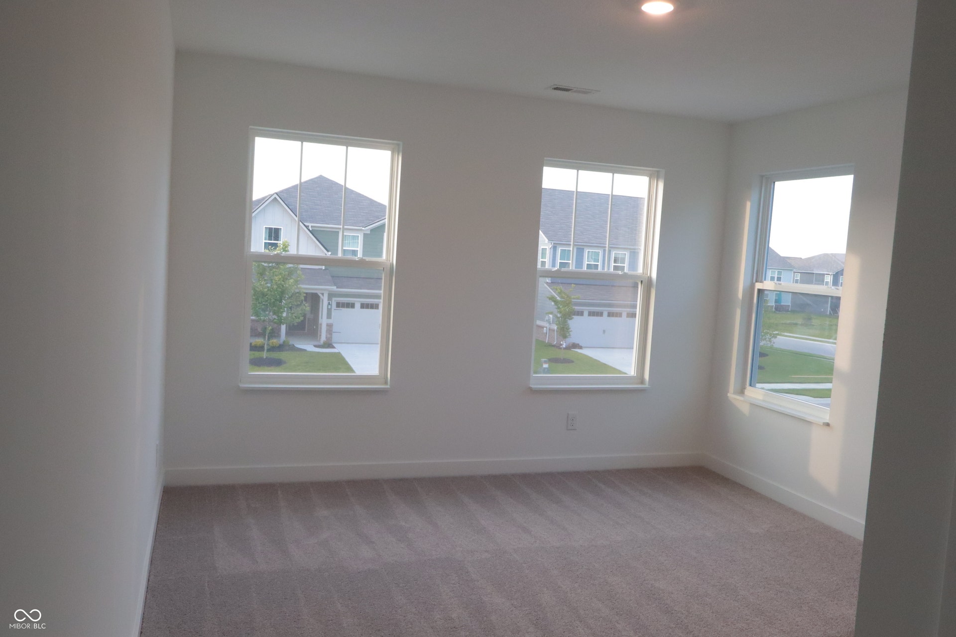 Spacious room with plush carpet flooring and white painted walls