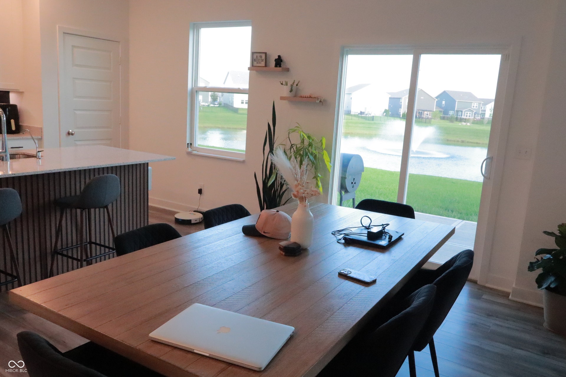 Sliding glass doors provide access to an exterior space and offer a water feature backdrop