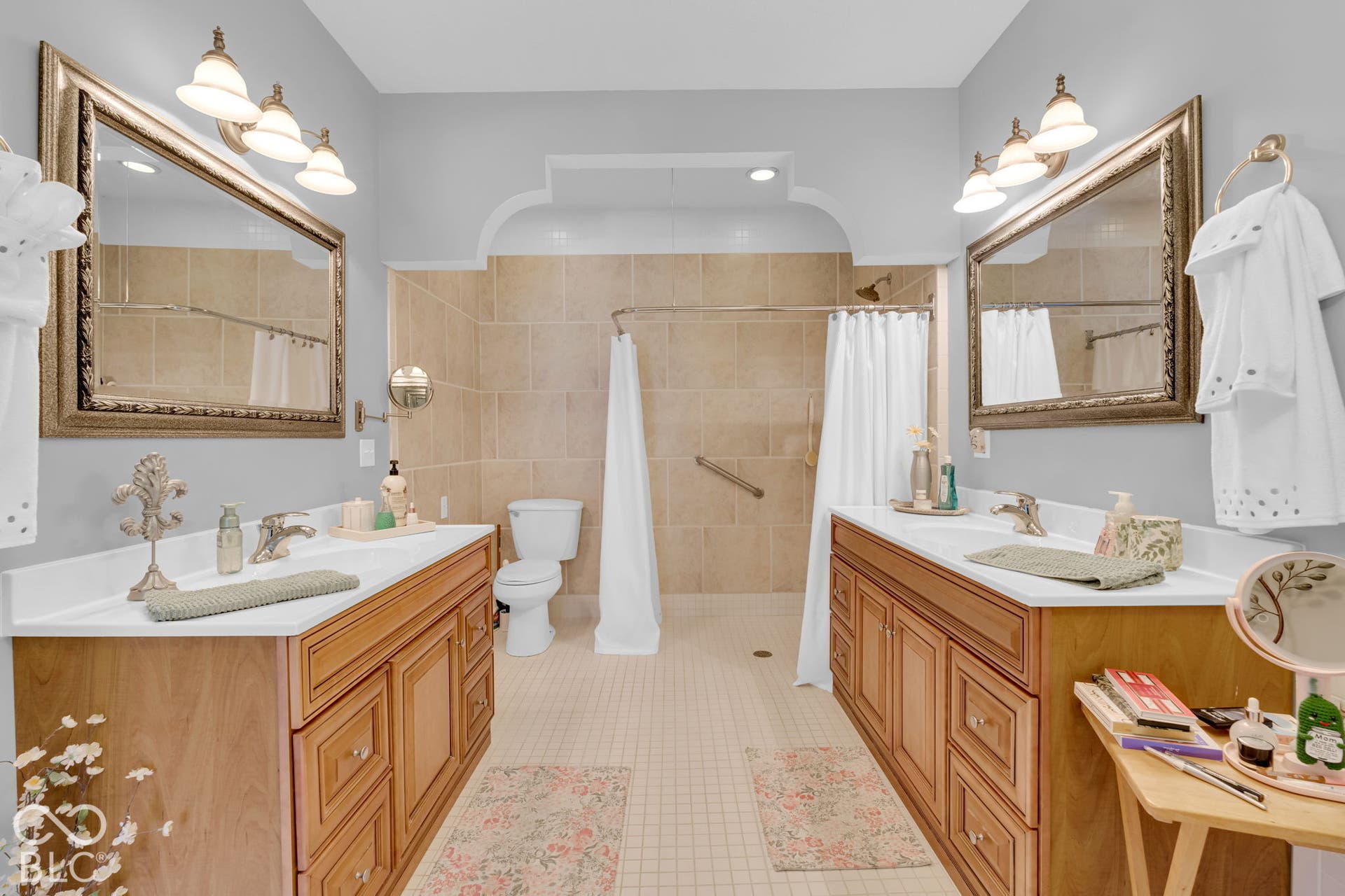 Primary bathroom with two sinks and full shower stall with handicap hand-rail.