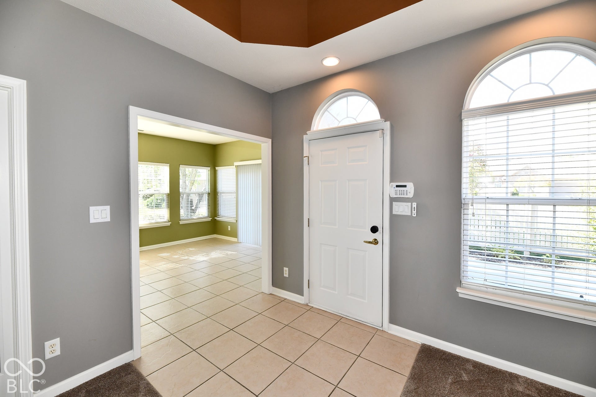 6673 Avila Way, Fishers, IN 46038 Entry foyer featuring large arched windows, tile flooring, and a recessed ceiling with accent paint