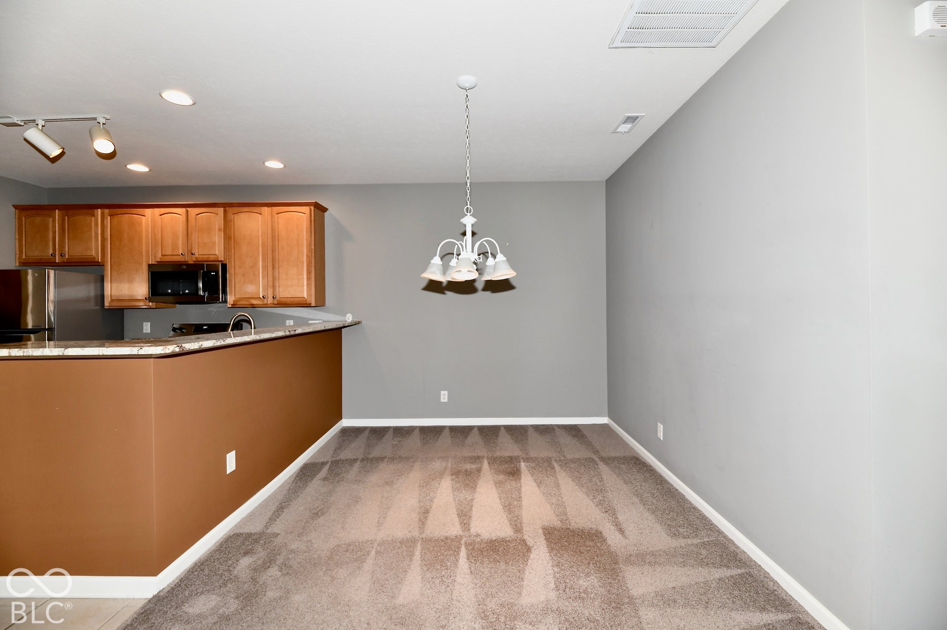 6673 Avila Way, Fishers, IN 46038 Kitchen featuring wood cabinetry, stainless steel appliances, and a breakfast bar with granite countertops