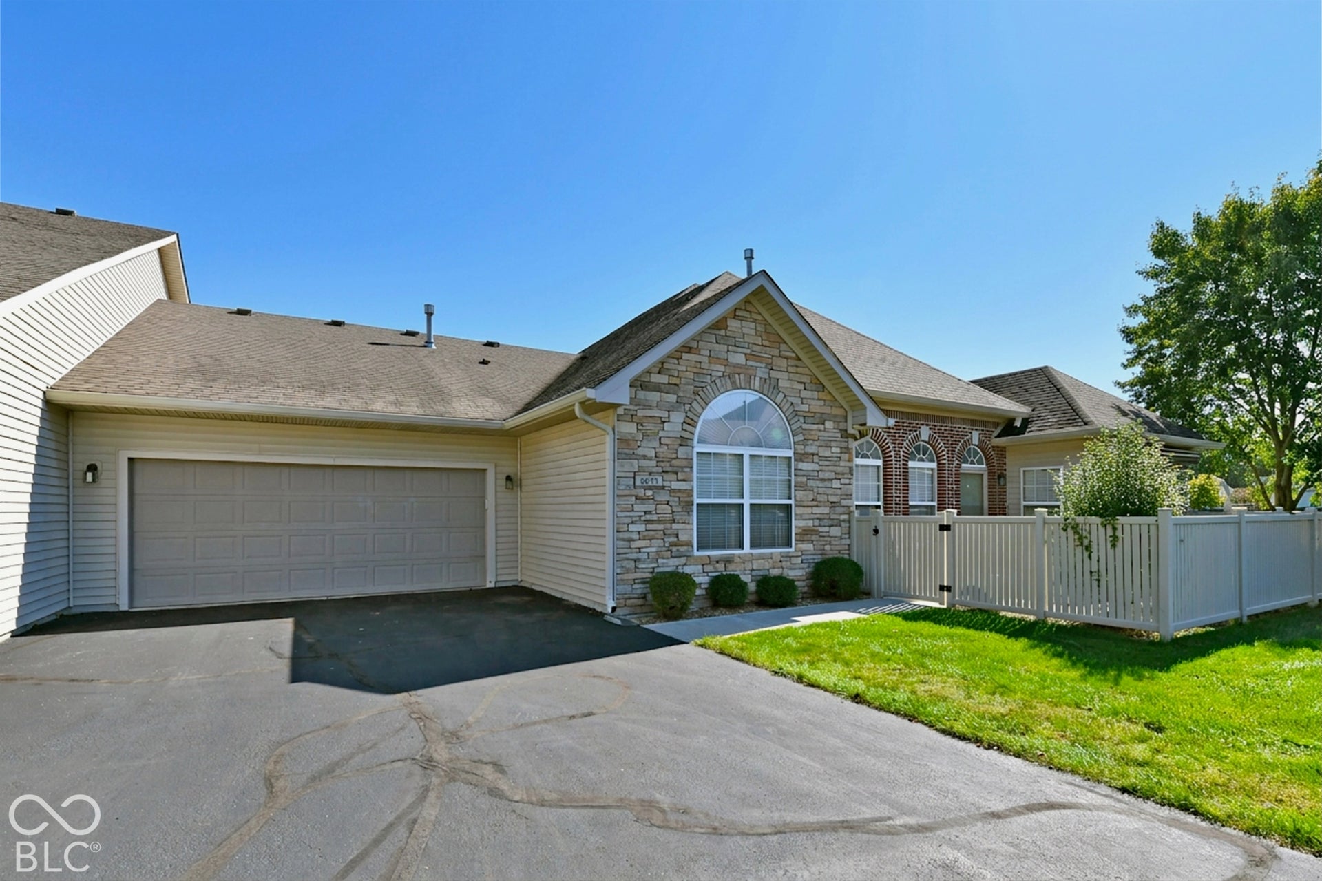 6673 Avila Way, Fishers, IN 46038 Stone and siding exterior with an arched window, attached garage, and paved driveway